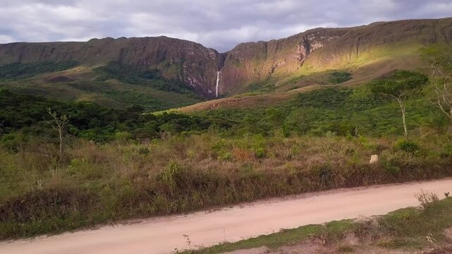 A scenic view of Serra da Canastra in Minas Gerais, Brazil, showing lush green hills and a waterfall