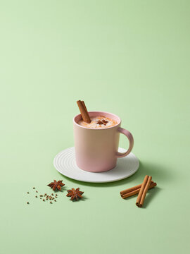 Pink Mug With Spiced Beverage Garnished With Cinnamon and Anise
