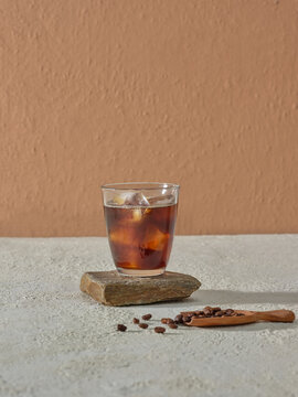 Iced Coffee Beverage on Stylish Stone with Coffee Beans and Spoon
