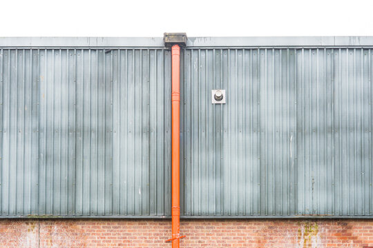 Red drainpipe on a warehouse exterior wall