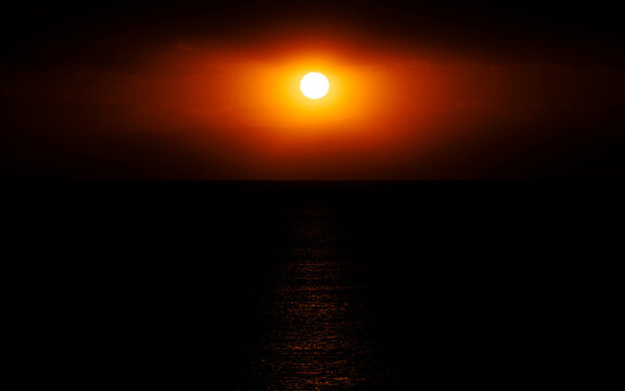 Sunset at sea, golden light spilling across the water.