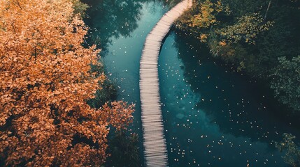 A breathtaking aerial view of the wooden walkpath in Plitvice National Park, weaving through a serene autumn forest and lake.