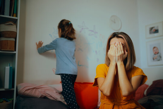 Mother Desperate As Her Disobedient Daughter Scribbles on the Walls. Exasperated mom feeling upset because of her naughty child 