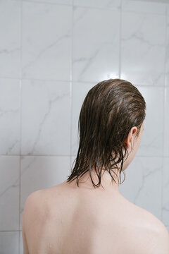 Back view of young man with wet hair in shower