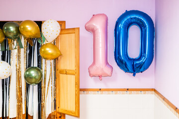 Pink and blue number ten balloons hanging on wall