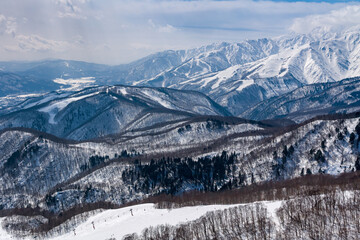 Snow covered mountain and forest alpine scenery on a sunny day. Hakuba, Nagano