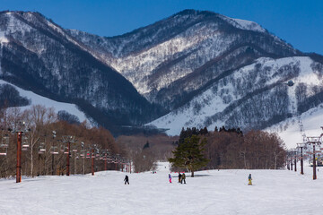 Winter sports activities on a sunny day at Tsugaike ski resort, Japan