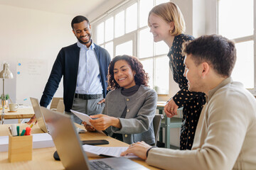 Happy formal business team celebrating success in office meeting