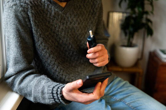 Man with electronic cigarette and smartphone