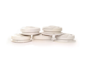 Many smoke detector with carbon monoxide alarm. Stack of old smoke detectors to recycle. Fire safety product for homes, apartments, stores and buildings. Selective focus. White background.