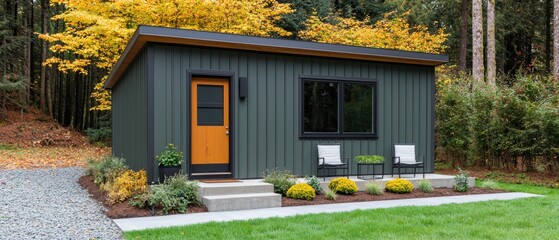 Accessory dwelling unit concept. Modern green cabin in serene forest setting with outdoor seating.