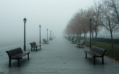 Foggy autumnal park path with benches and lampposts, gray and orange tones, misty atmosphere