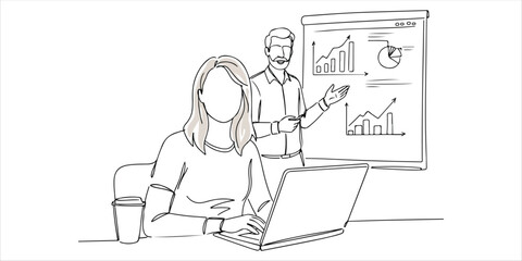 A woman sits at a table, focused on her laptop, engaged in her work. In front of her, a man stands, presenting key insights against a backdrop of graphs. The scene reflects a professional environment 