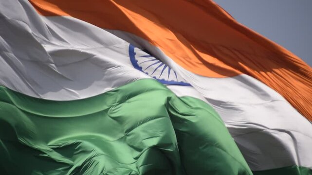 India flag flying high at Connaught Place with pride in blue sky, India flag fluttering, Indian Flag on Independence Day and Republic Day of India, tilt up shot, Waving Indian flag, Har Ghar Tiranga