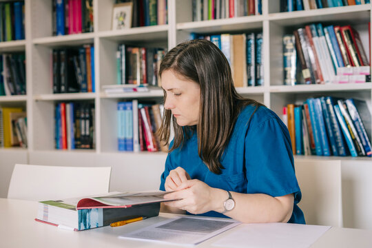 Veterinarian Reading a Medical Book in the Clinic's Library