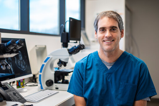 Veterinarian smiling in his clinic with microscopes and computers