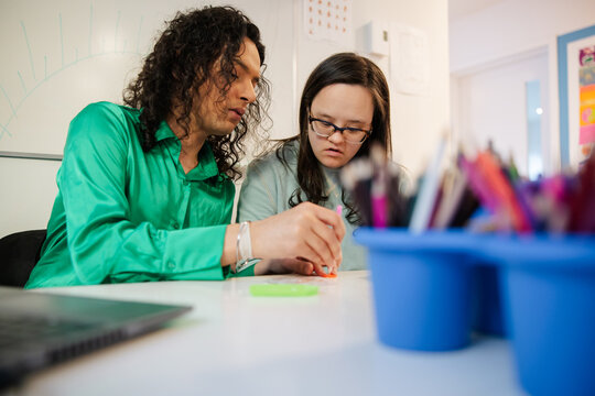 Teacher Collaborating with Student During Creative Art Activity