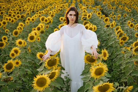 A girl walking through a field of sunflowers