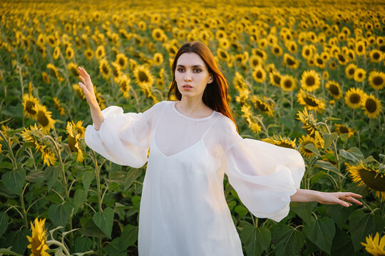 A girl in a sunflower field at sunset