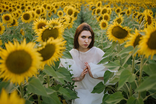 A girl in sunflowers performing a ritual.