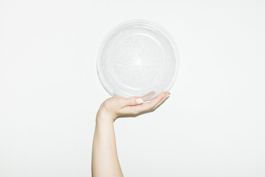 Hand holding clear geometric plastic rounded bubble with flash