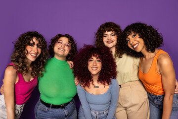 Group of diverse women with curly hair smiling together