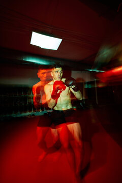 Boxer training in intense red lighting with fast-paced movement