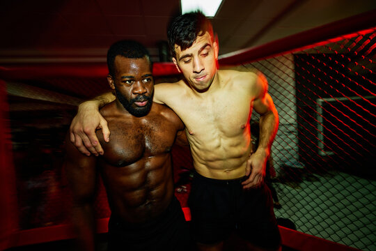 Two fighters pose after intense training session in gym
