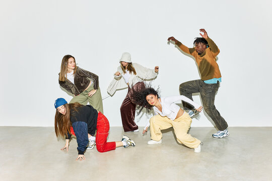 Group of dancers performing dynamic moves in studio setting - Powered by Adobe