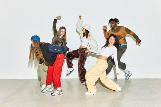 Group of friends dancing joyfully in a bright studio space