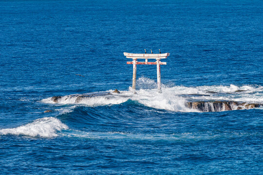 Waves Crashing Against A Weathered Torii Gate