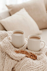 Cozy mugs of coffee on soft blanket create warm and inviting atmosphere