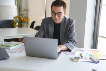 Fototapeta premium Business asian Man Artist Creative Designer sketch graphic drawing on graphic laptop and Color swatch samples Concept of idea creativity