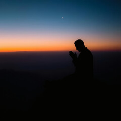 Fototapeta premium Man Praying on Mountain at Sunset with Single Star