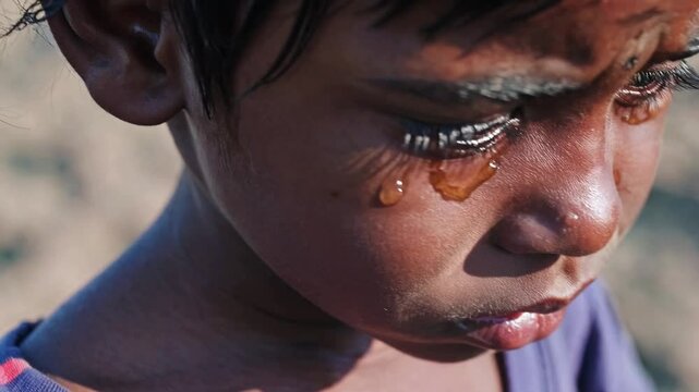 Close-up portrait of a young sad Indian boy with tears on his cheeks