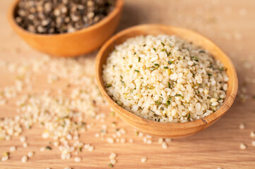 Hemp seeds in wooden bowl on wooden table, top view. Superfood, natural organic seeds for healthy...