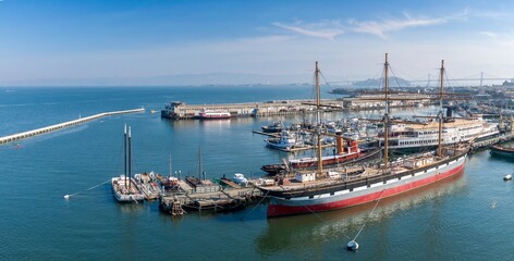 Aerial view of historic ships docked at Hyde Street Pier, part of the San Francisco Maritime National Historical Park, in California, USA. Tourists visit to learn about maritime history.