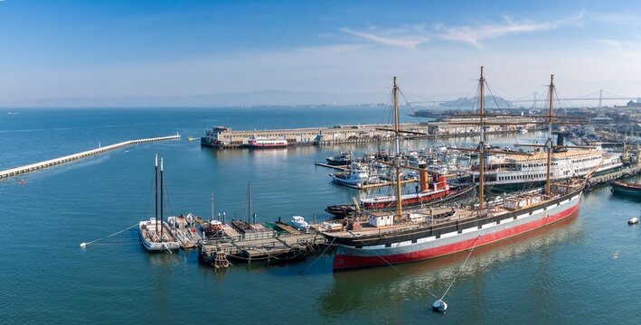 Aerial view of historic ships docked at Hyde Street Pier, part of the San Francisco Maritime National Historical Park, in California, USA. Tourists visit to learn about maritime history.