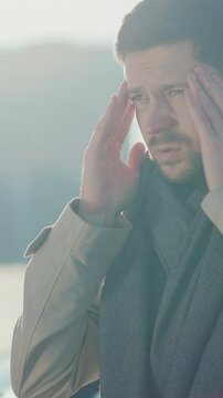 Bearded young businessman sneezing allergy while using phone outdoor. Happy smiling sick guy purchasing antiviral medicine online. E-commerce. Healthcare.