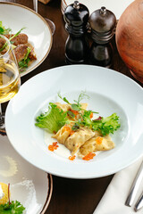 ravioli with sauce, herbs and caviar in a restaurant