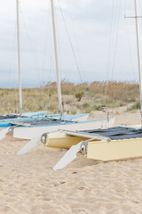 Close-up of catamarans resting on sandy beach shore.