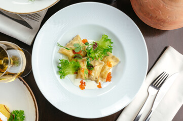 ravioli with sauce, herbs and caviar