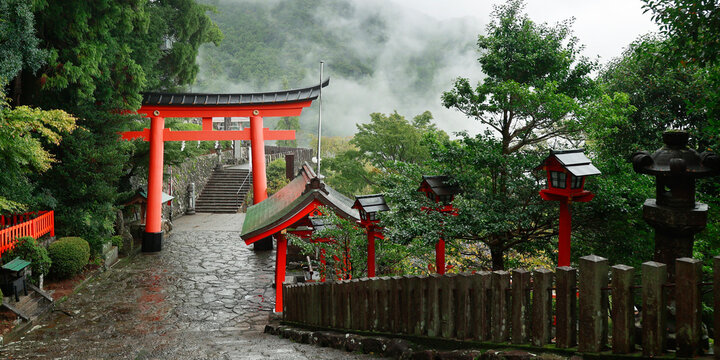  view of Japanese temple and torri gate  in misty mountains