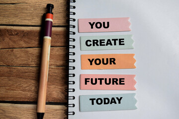 Concept of You Create Your Future Today write on sticky notes isolated on Wooden Table.