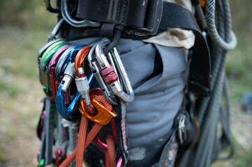Climber wearing harness with carabiners and rope preparing for climbing