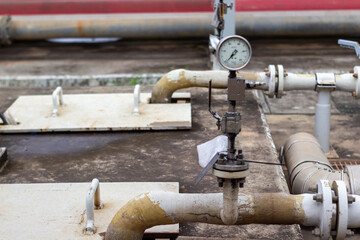 Industrial pressure gauge on outdoor piping. Monitors system pressure for process control and safety in a plant