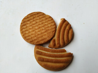 Round Whole Brown Color Biscuit and Cut Cookie isolated on white Background. Curve Shape pattern above the biscuit.