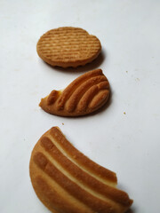 Round Whole Brown Color Biscuit and Cut Cookie isolated on white Background. Curve Shape pattern above the biscuit.
