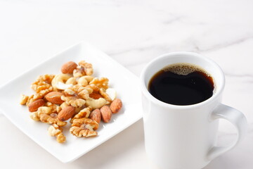 栄養たっぷりのミックスナッツと、淹れたてで香りのよいコーヒー
