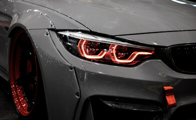 Headight of a grey car. Red headlight.